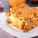 Baked pasta with peas, eggplant and egg on complex background